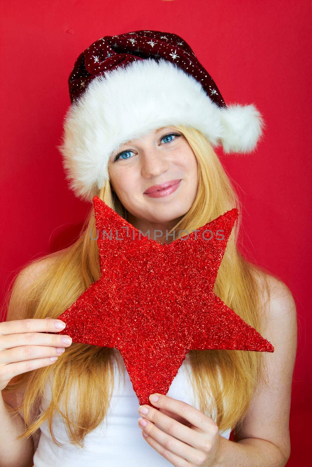 beautiful blonde girl wearing a christmas hat is smiling