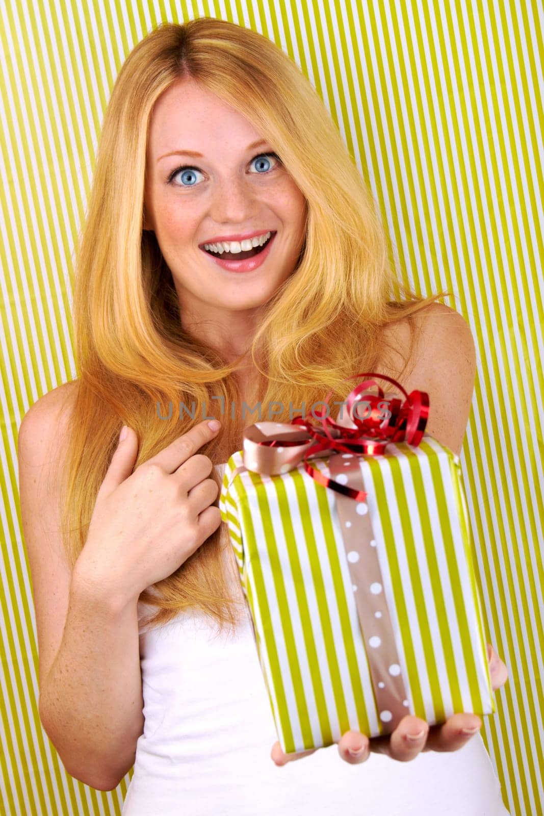 beautiful blonde woman holding a christmas gift is smiling
