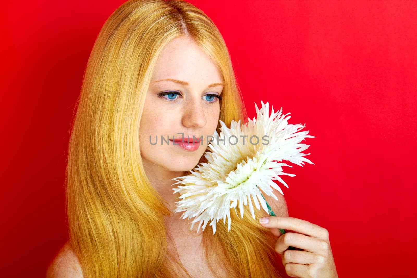portrait of a young beautiful blonde girl with flower