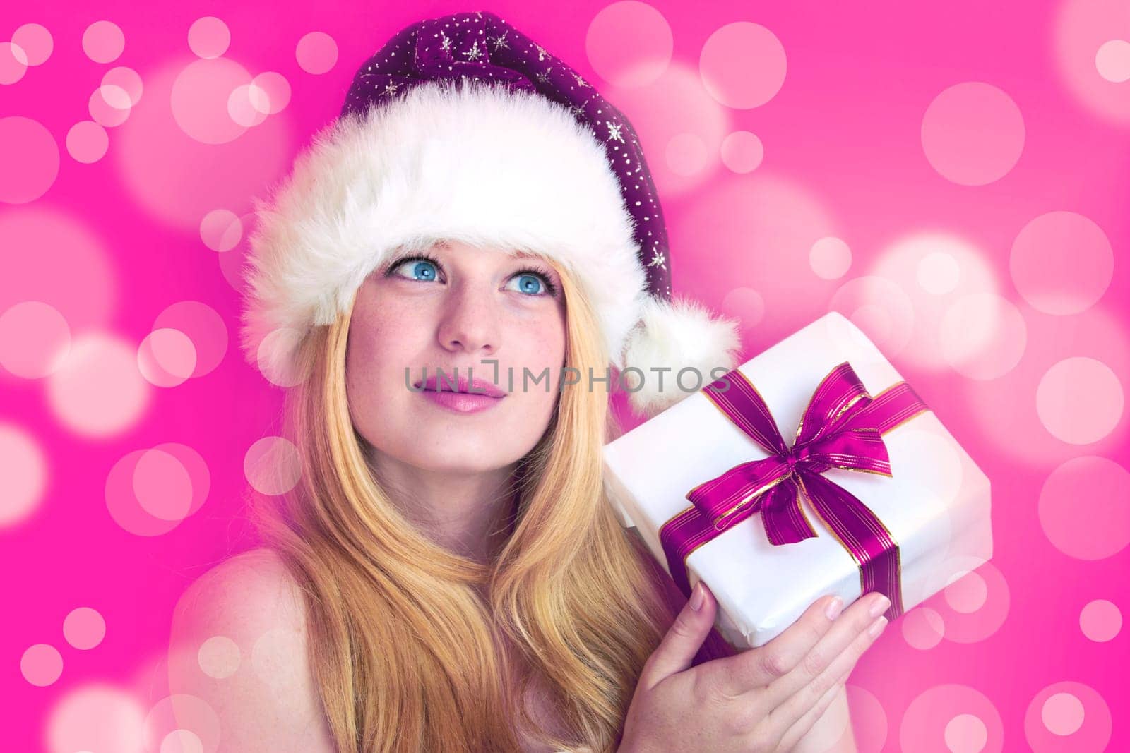 beautiful blonde woman holding a christmas gift is smiling
