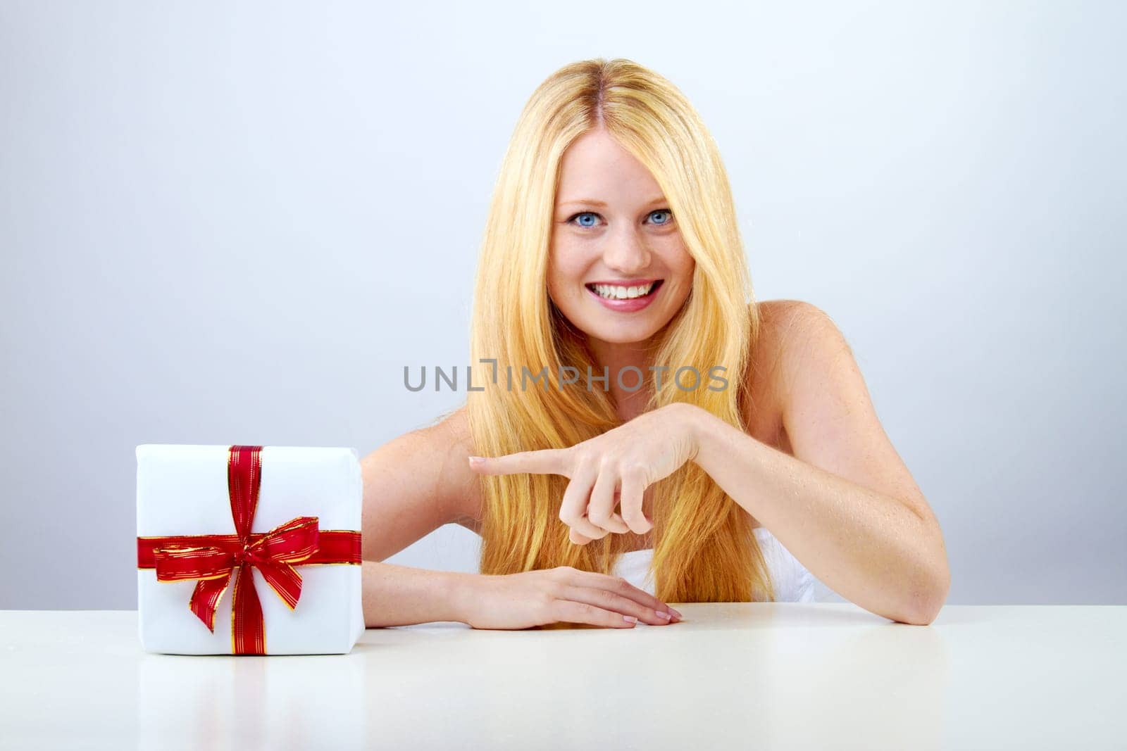 beautiful blonde woman holding a christmas gift is smiling