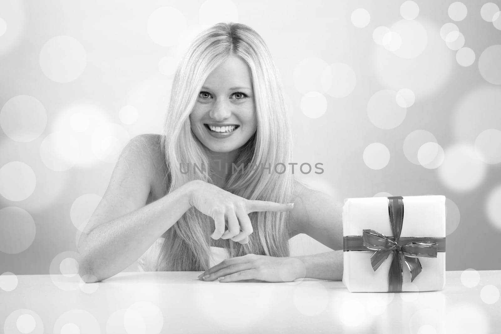 beautiful blonde woman holding a christmas gift is smiling