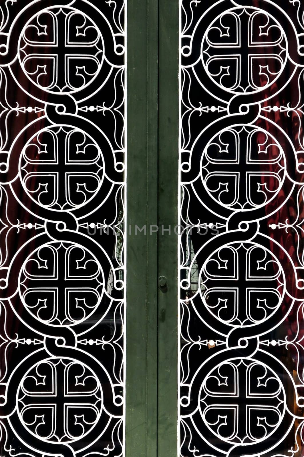 Tangled circles and cross christian religious icon pattern detail on iron church door.