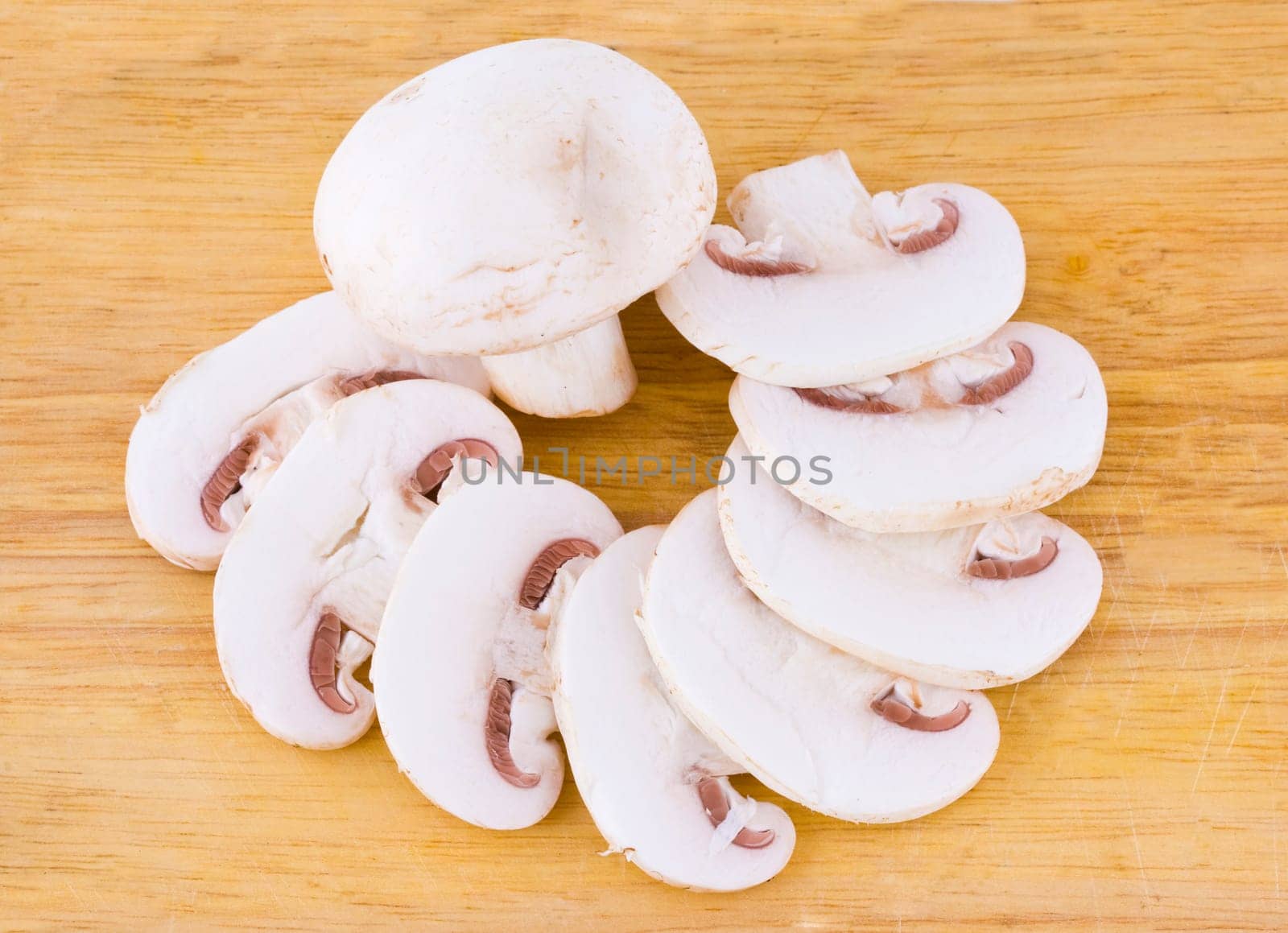Sliced mushrooms on the wooden cutting board background
