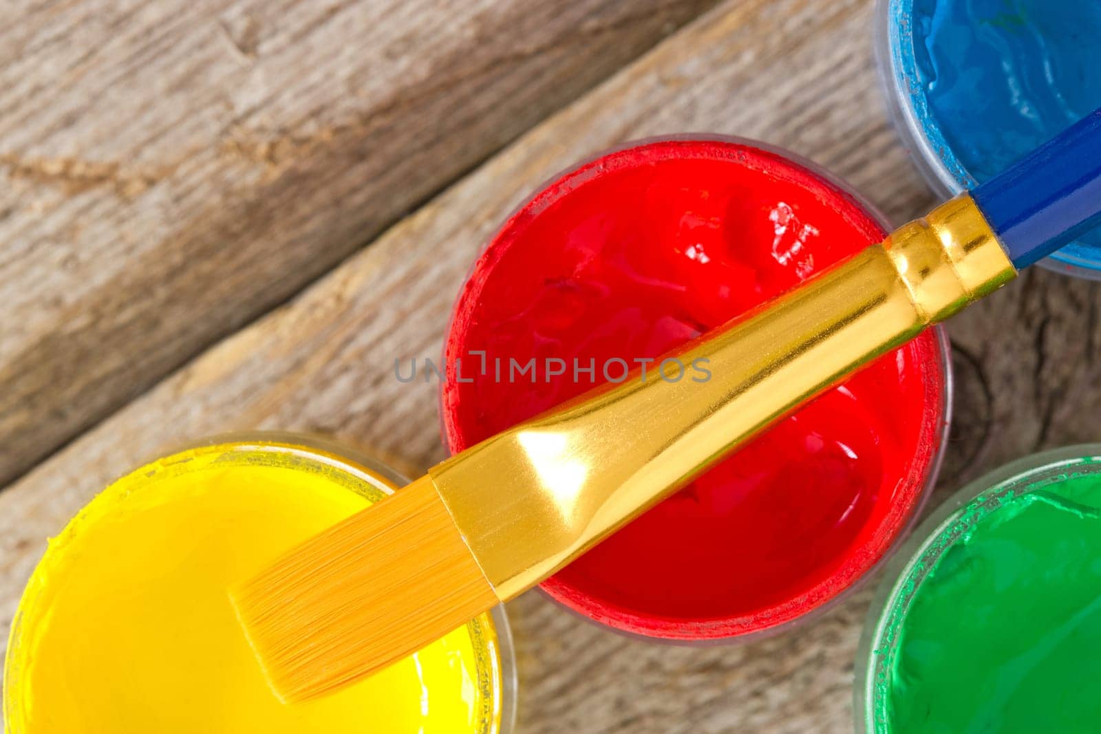 color paints with paintbrush on the wooden plank