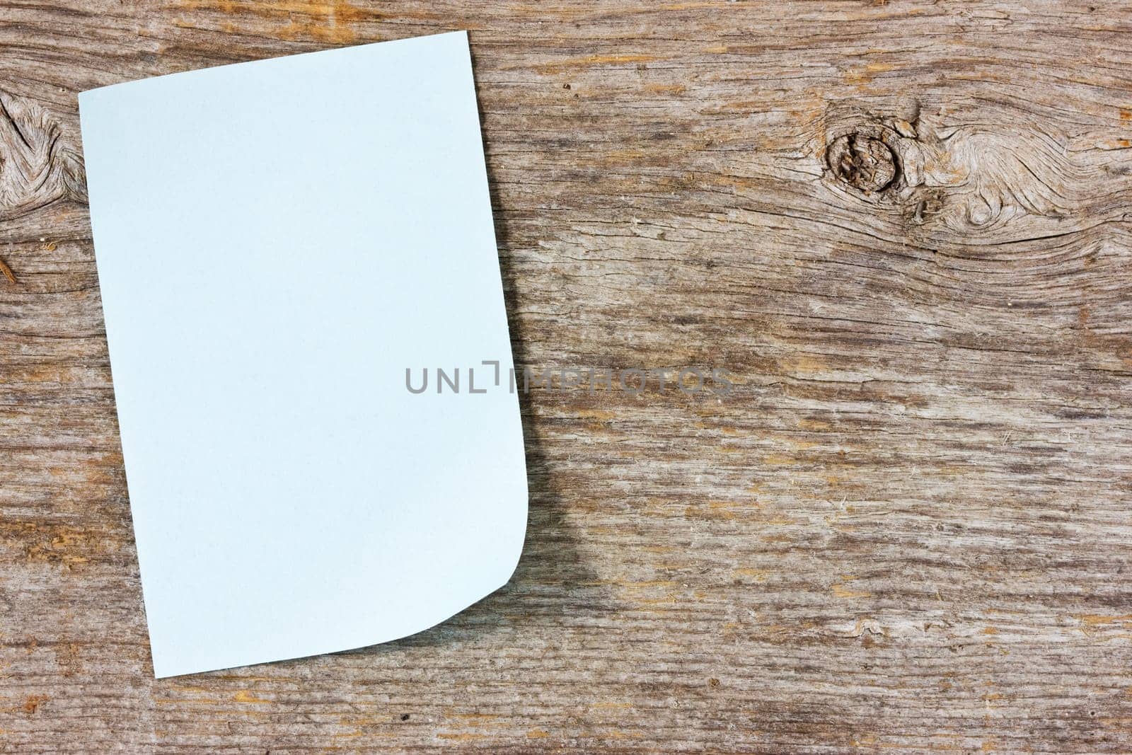 Blank sticky note on the wooden background