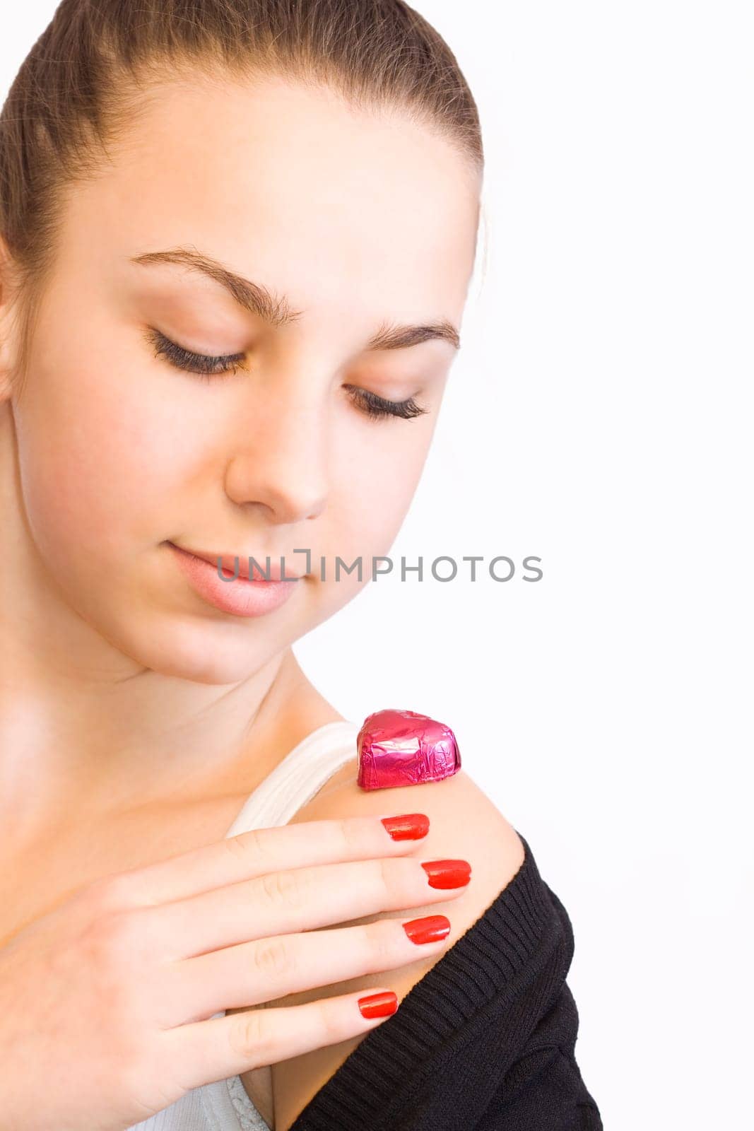 Valentines day girl with chocolate heart candy on her shoulder