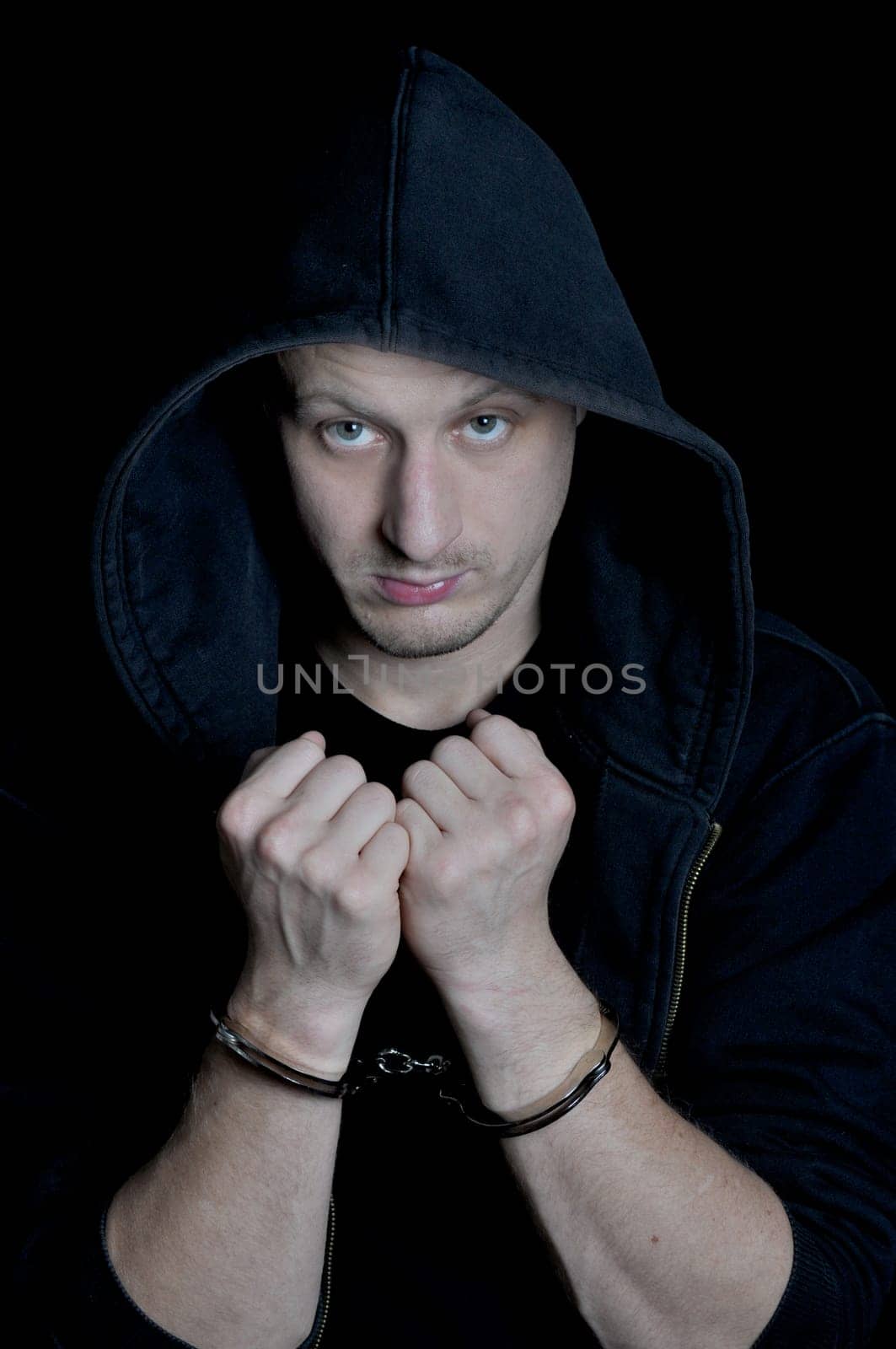 Arrested young men with handcuffs on dark background