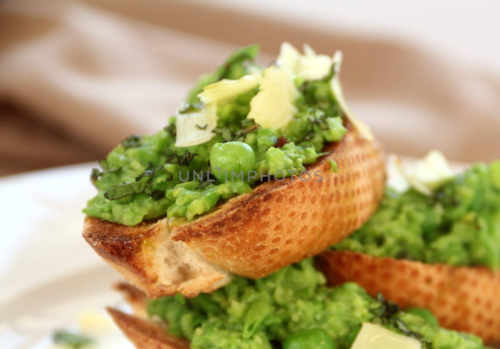 Delicious green pea baguettes with shaved cheese and mint with avocado oil.