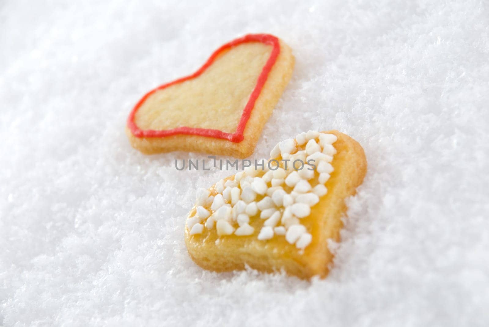 two self-baked heart cookies lying in the snow