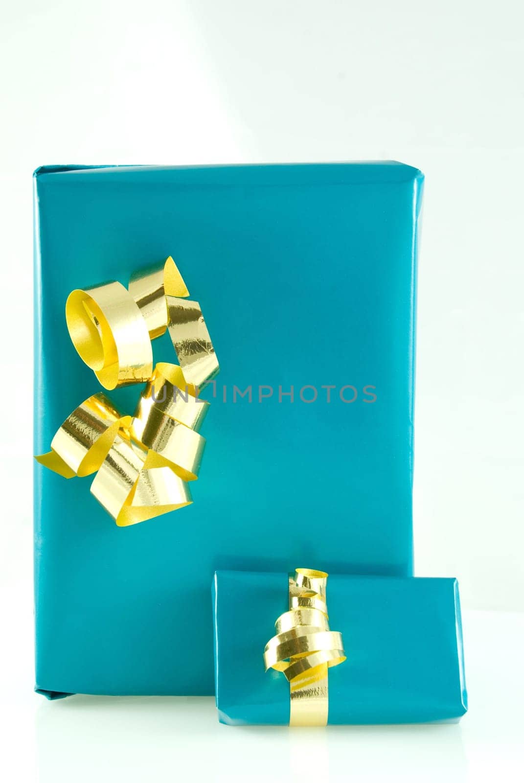 two blue gifts with gold ornamentation, on white