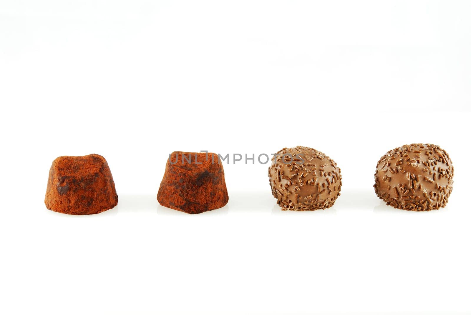 four chocolate candies in a row, two different kinds, on white