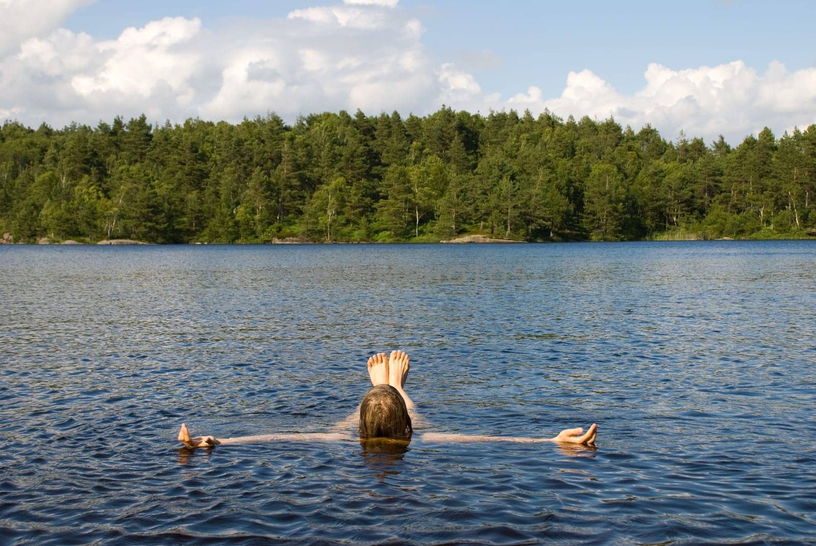 a person lying in the water for recreation i a natural environment