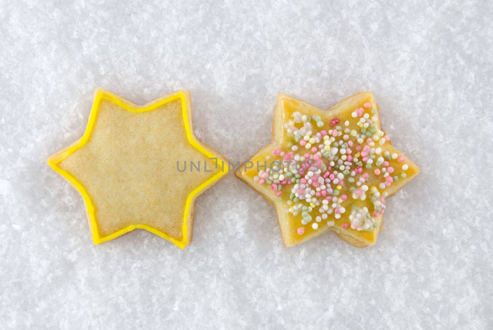 two christmas cookies in star-figure lying in the snow