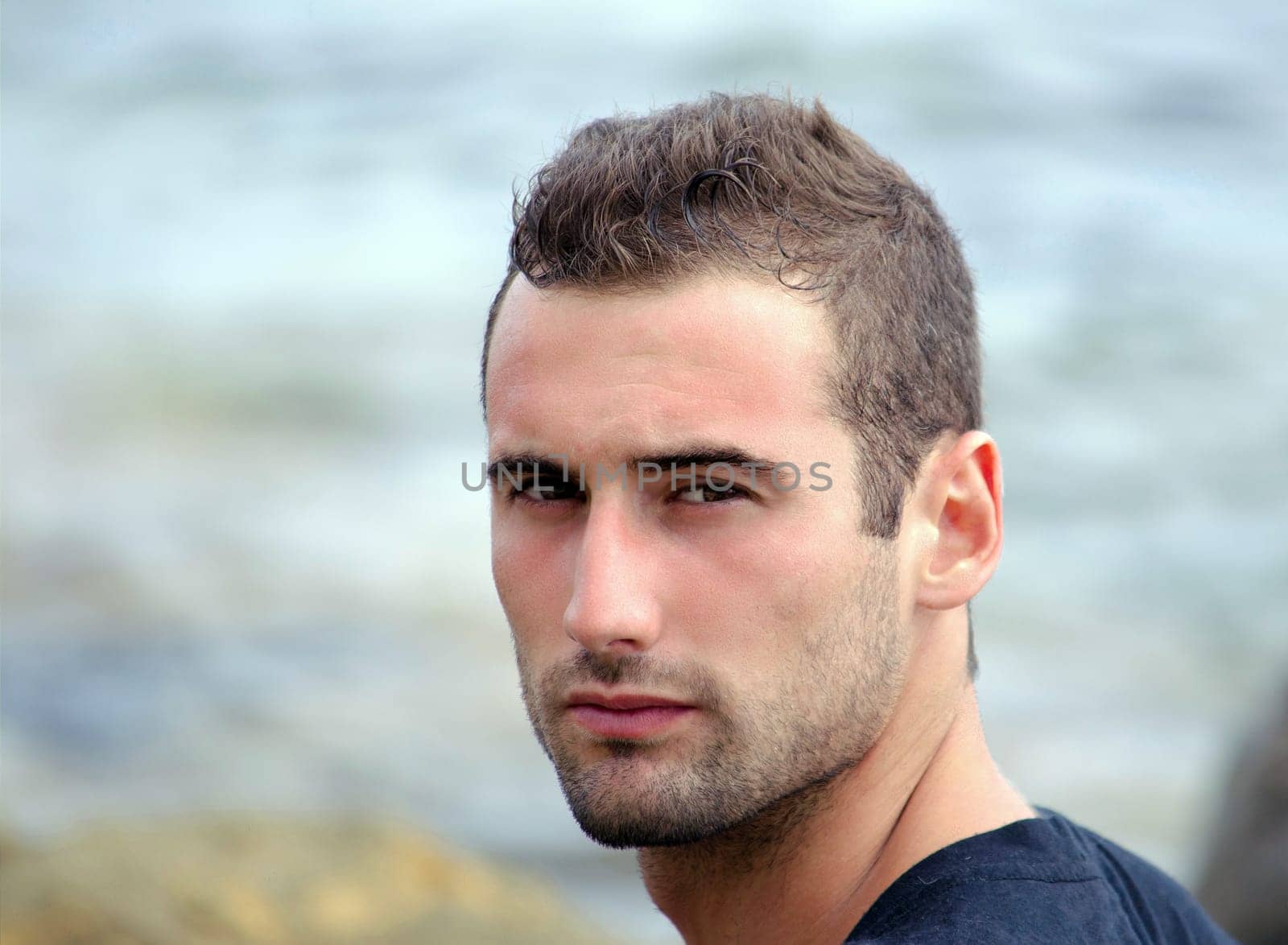 Portait of attractive and fit mediterranean looking young man by sea