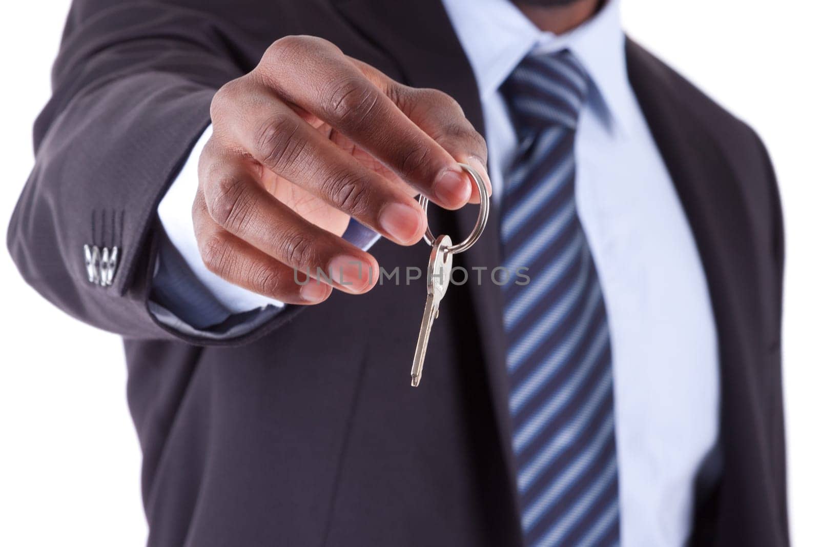 Young African American businessman holding a house key, isolated on white background