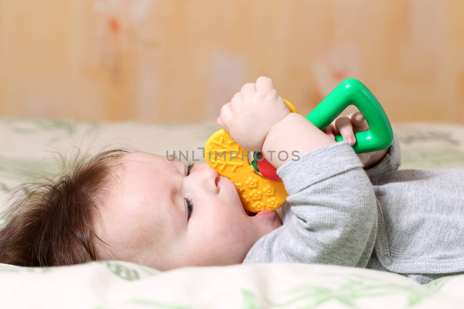 Portrait of a playing baby lying down on back