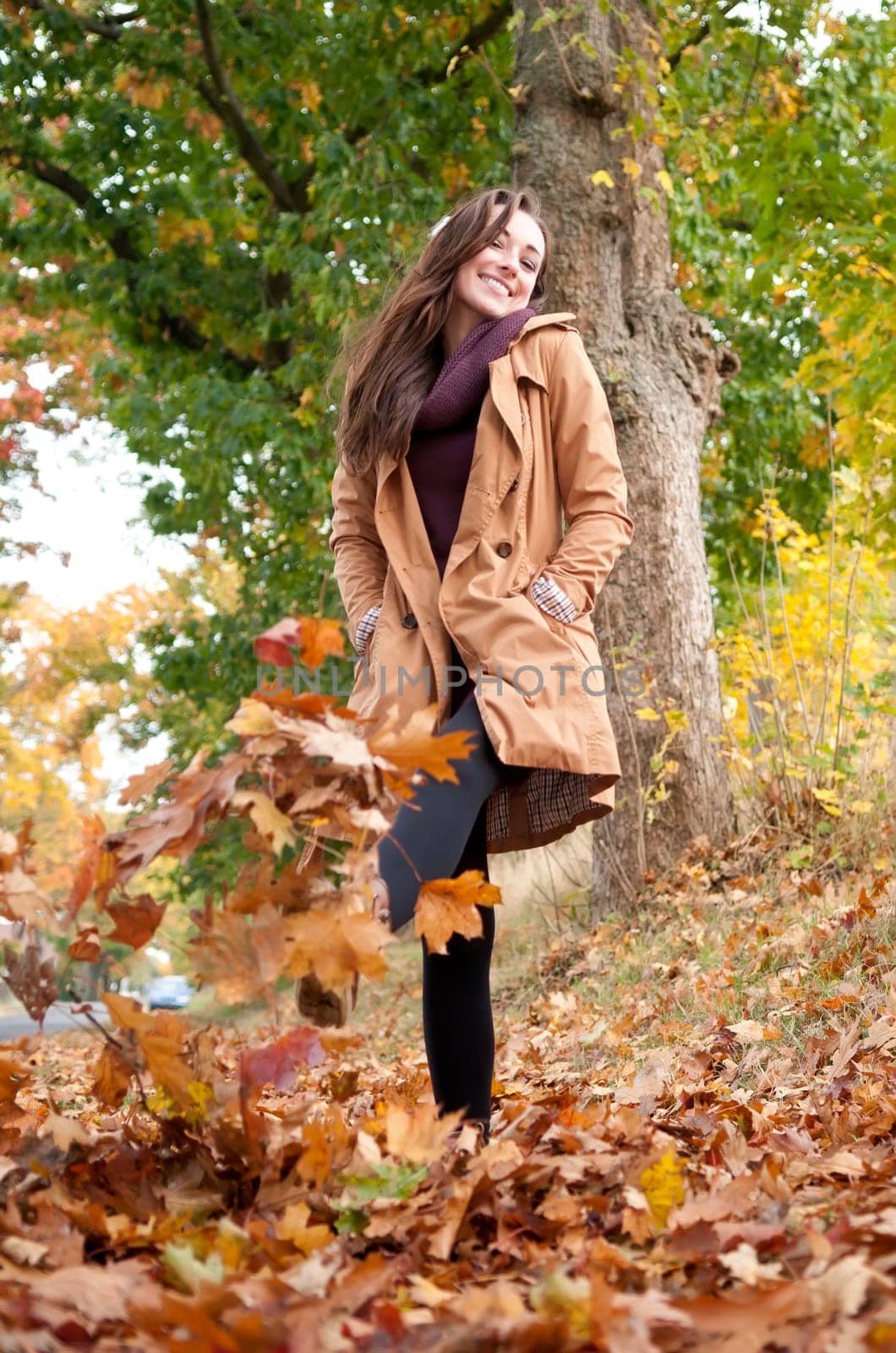 Young woman running in autumn leaves