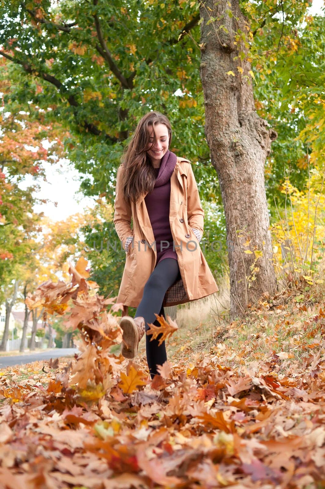 Young woman running in autumn leaves