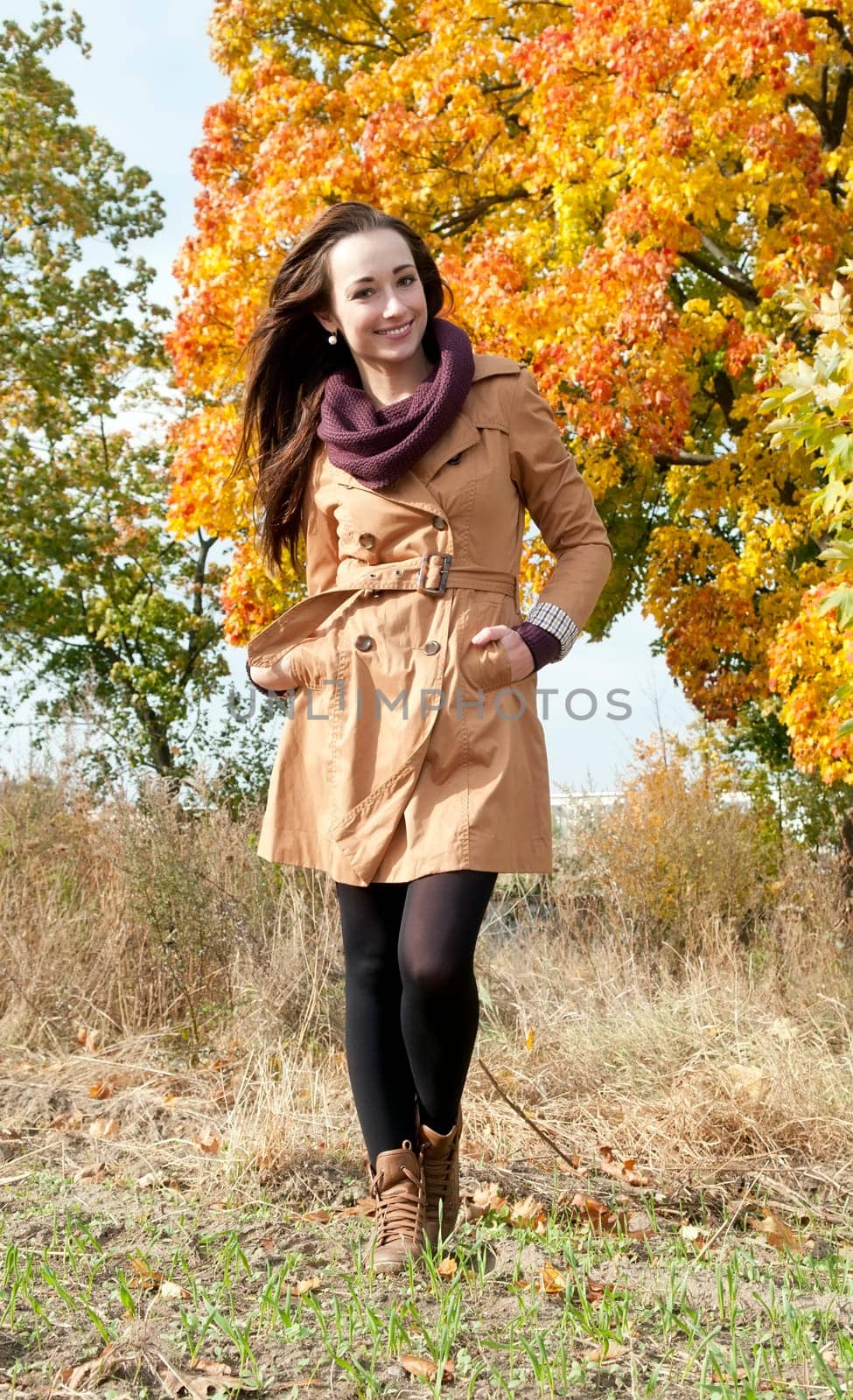 Cheerful young woman in autumnal park