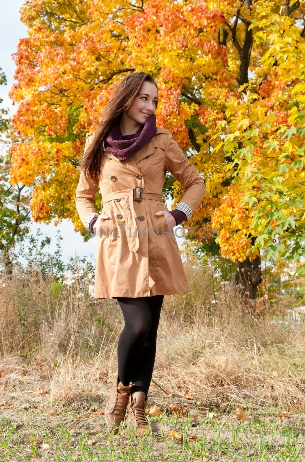 Cheerful young woman in autumnal park
