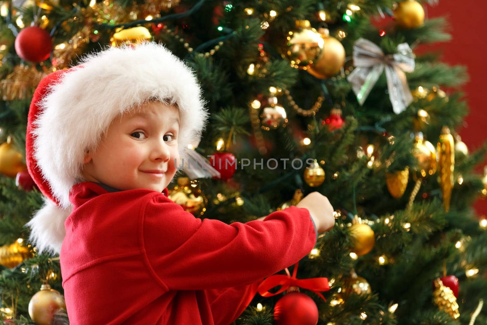 happy boy decorating Christmas tree