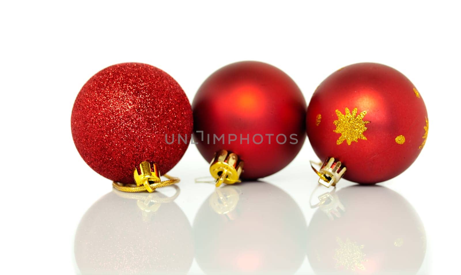 Red Christmas tree baubles decorations at xmas on white background with reflection