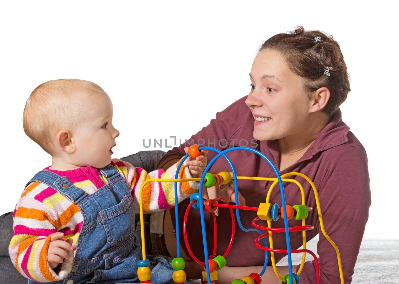 Baby with motor activity development delay being stimulated to develop coordination and muscle control and movement on a bead maze by an adoring mother