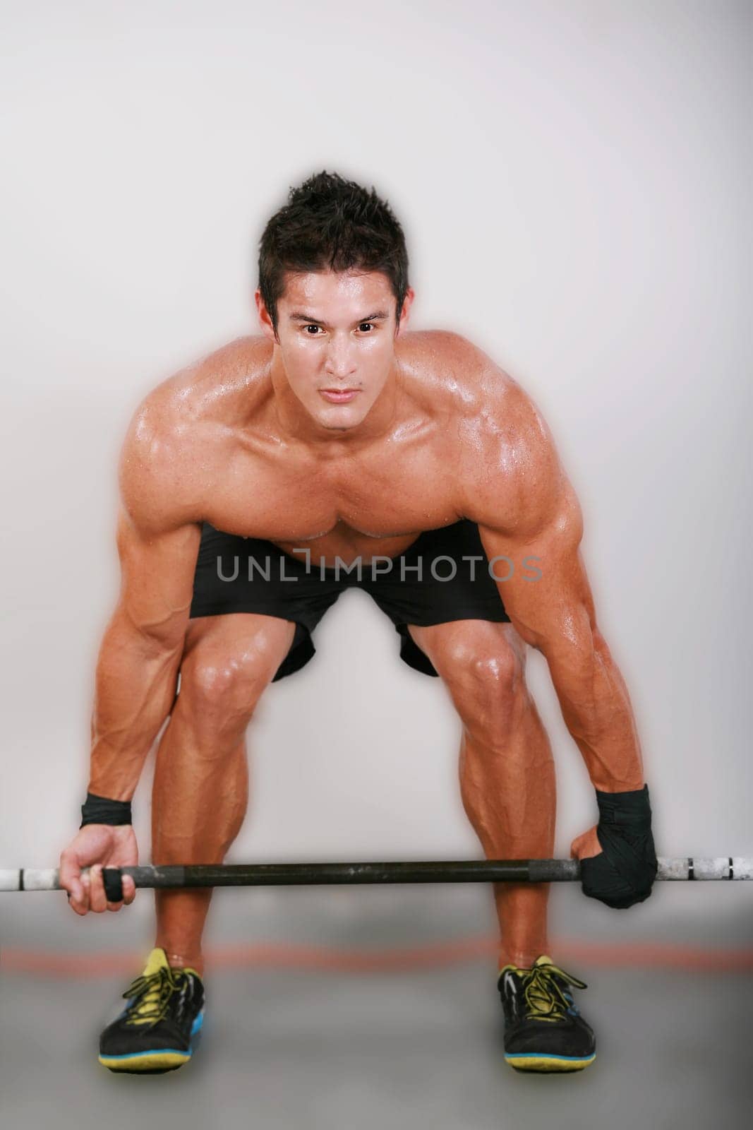 Young man lifting the barbell in the gym.