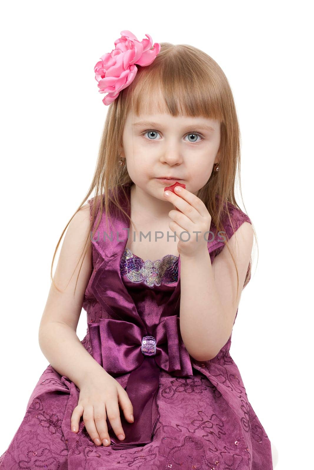 Little beautiful girl aged four eats marmalade. Isolate on white