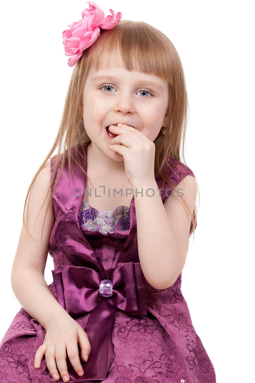 The little girl eats a jujube. Isolated on a white background