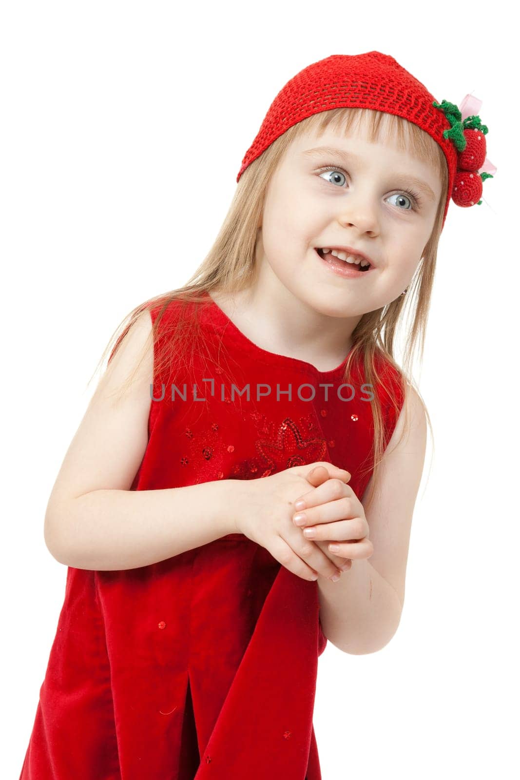 Portrait of a little girl in a red dress and a knitted cap with a strawberry pattern