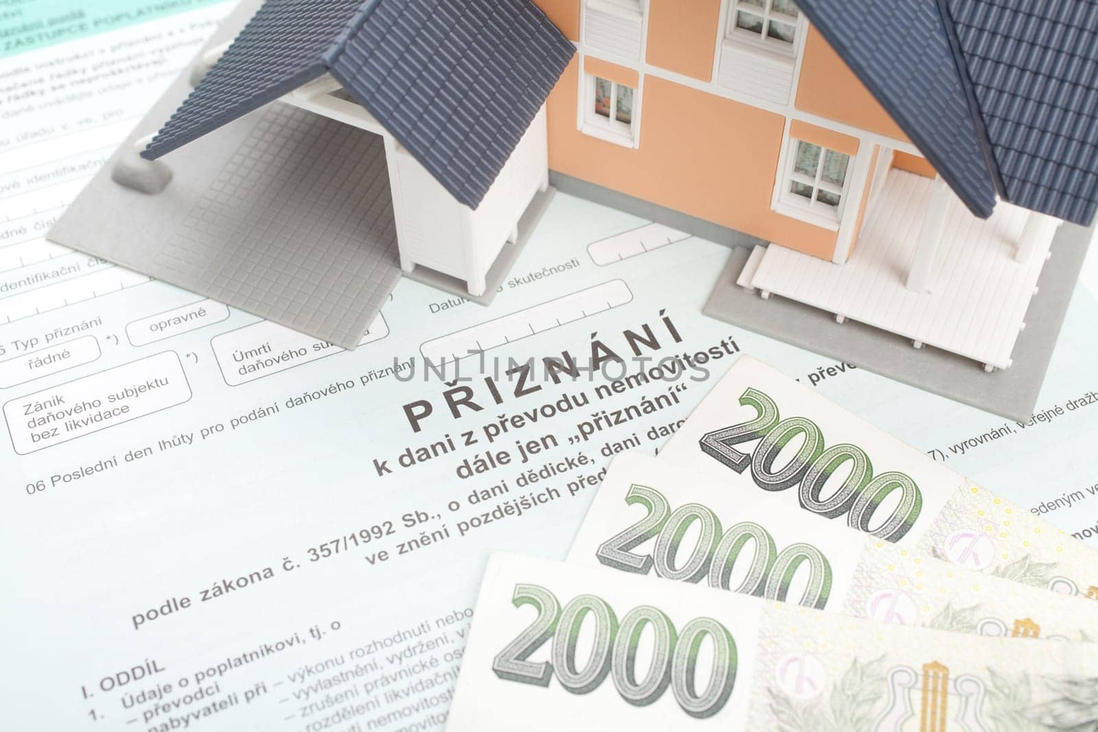 Czech property transfer tax form, model of the house and Czech money.
