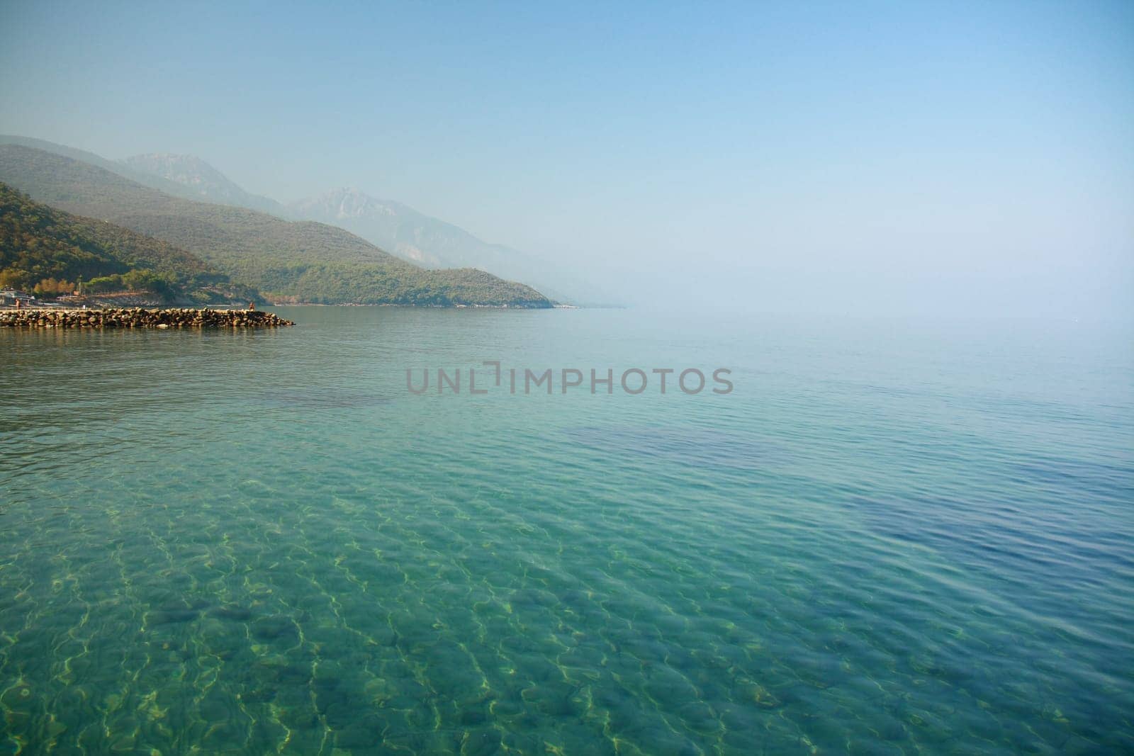blue sky and light green sea with smoke
