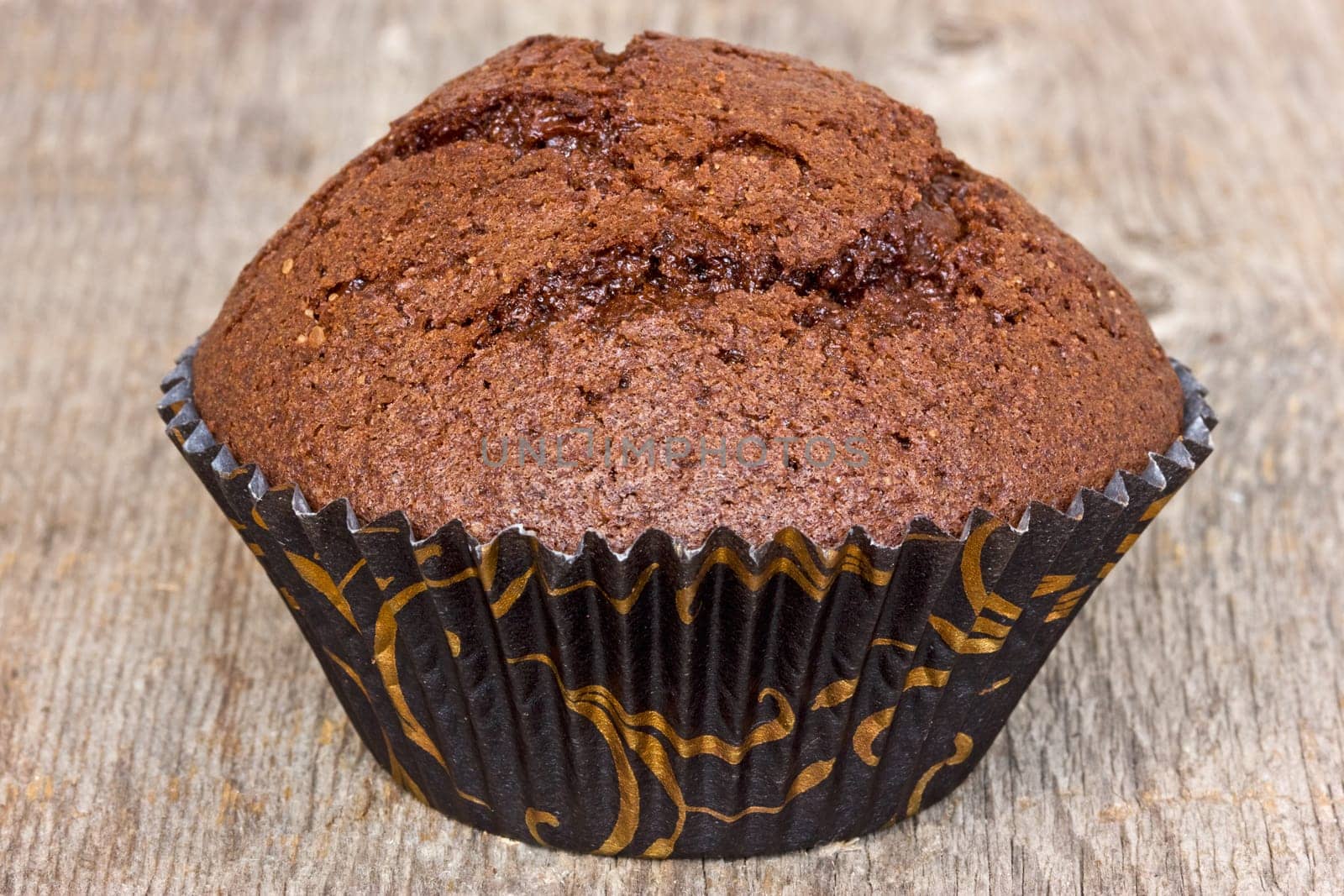 Chocolate muffin on the old  wooden plank