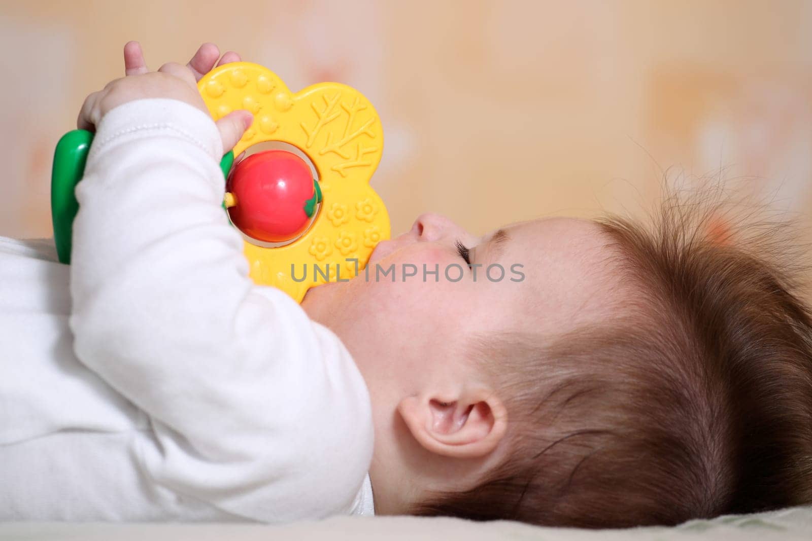 Portrait of a playing baby lying down on back