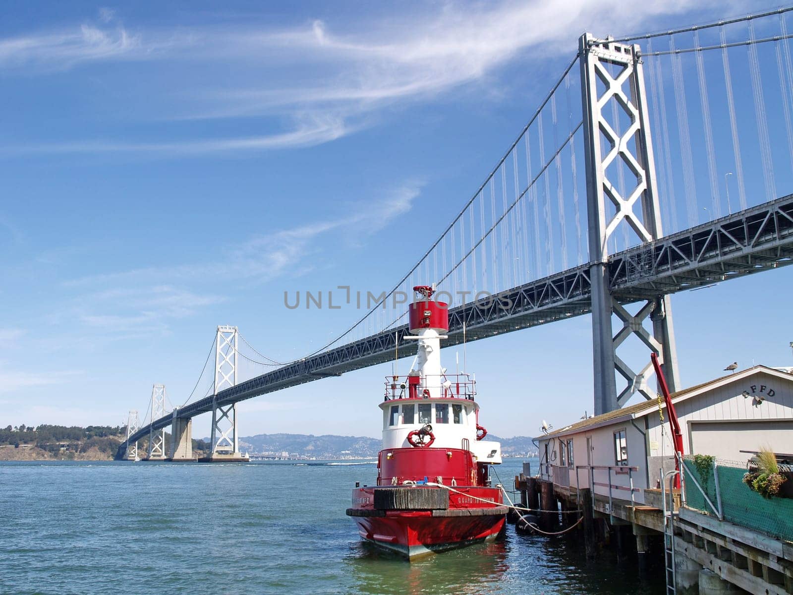 San Francisco Bay Bridge with a red ship