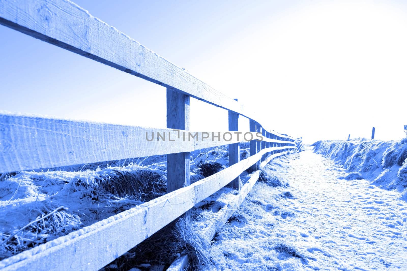 frosty blue winters view at ballybunion cliffside walk with bright sun and fence