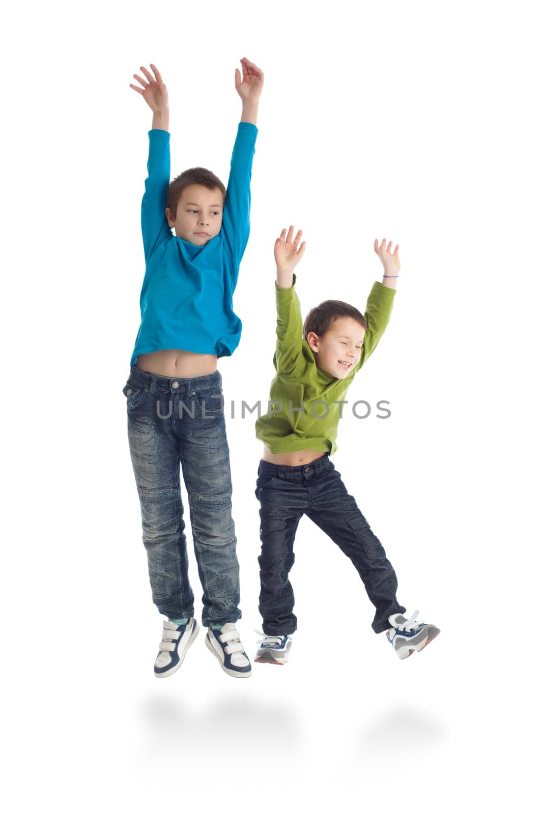 Two boys jumping on white background. Studio shot.