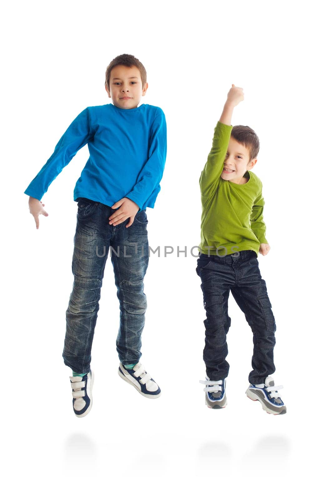 Two boys jumping on white background. Studio shot.