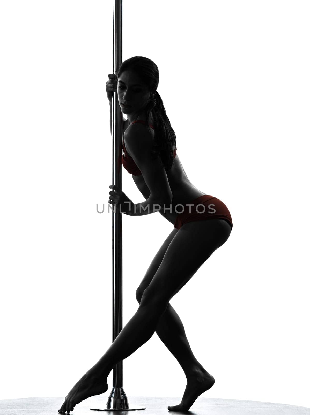 one caucasian woman pole dancer dancing in silhouette studio isolated on white background