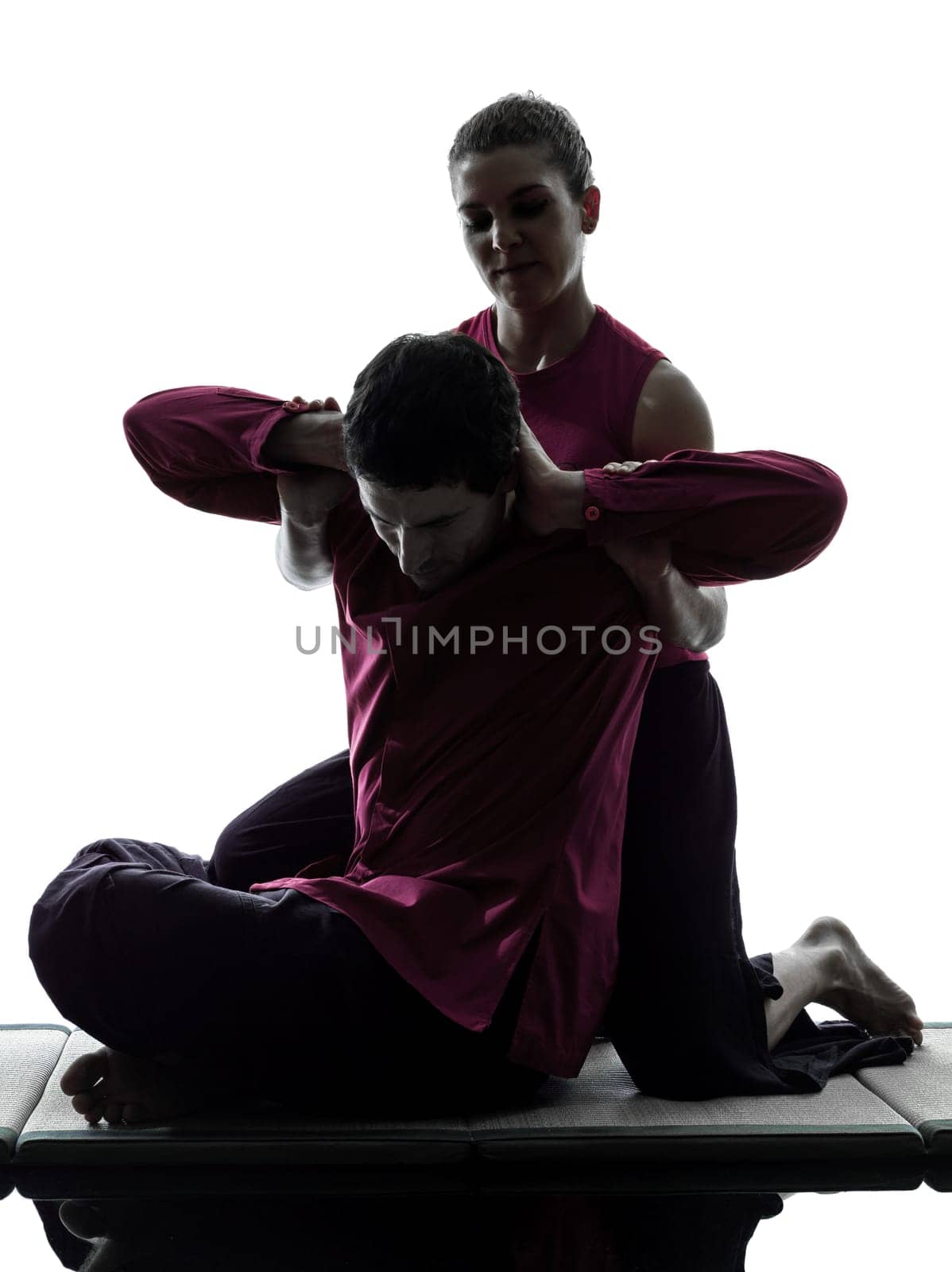 one man and woman perfoming thai massage in silhouette studio on white background
