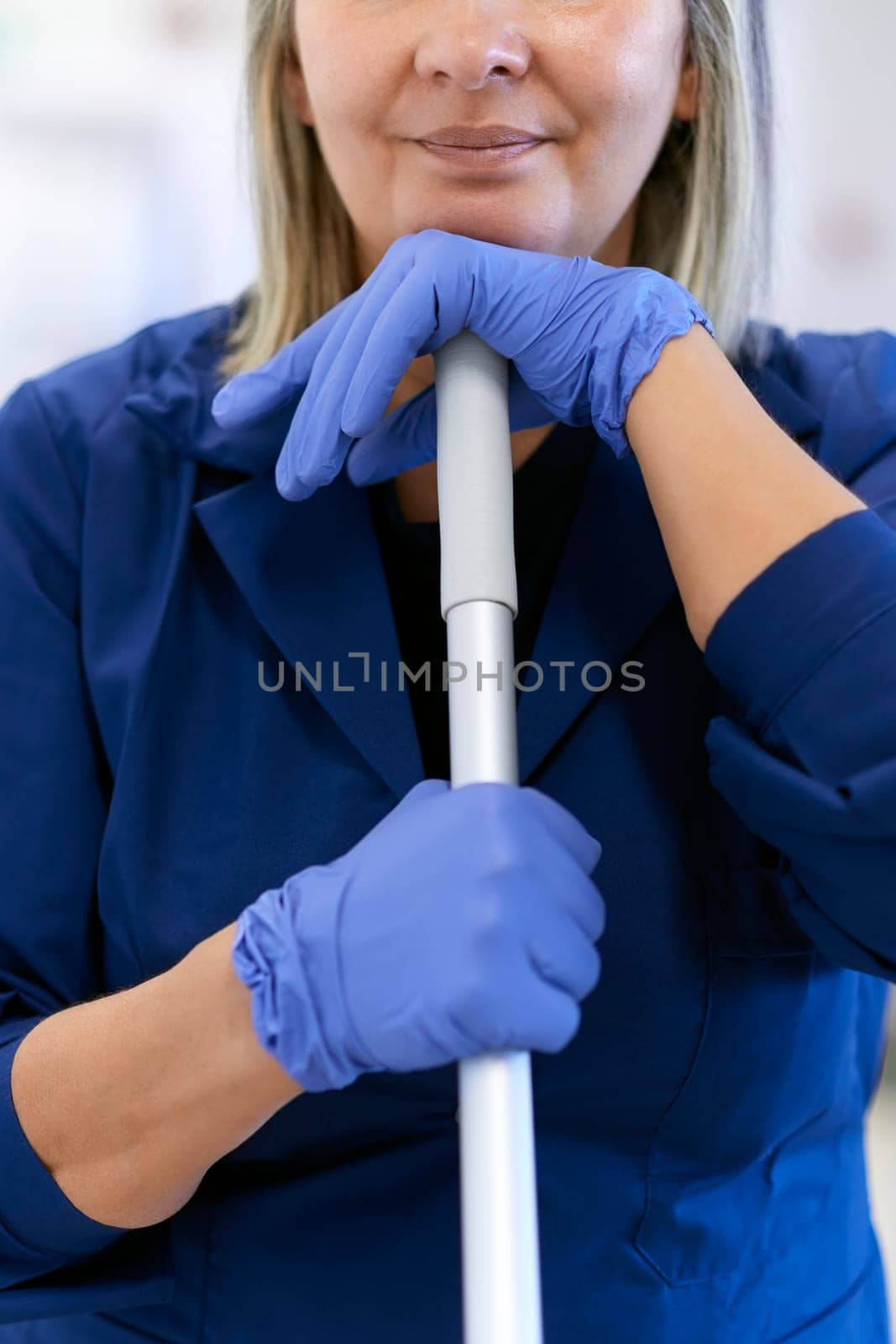 Women at work, portrait of happy professional female cleaner smiling and looking at camera in office. Cropped view