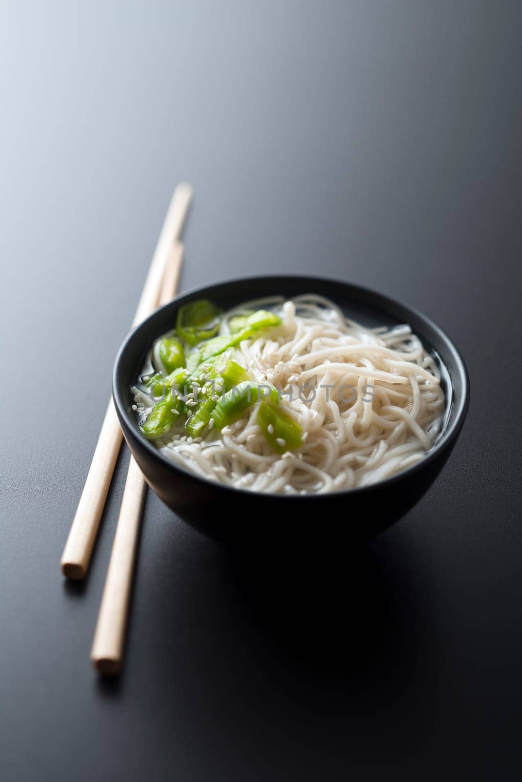 Chinese soup with noodles spring onion and sesame close up