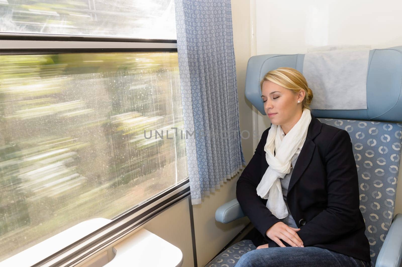 Woman asleep in train compartment tired resting commuter sleeping trip