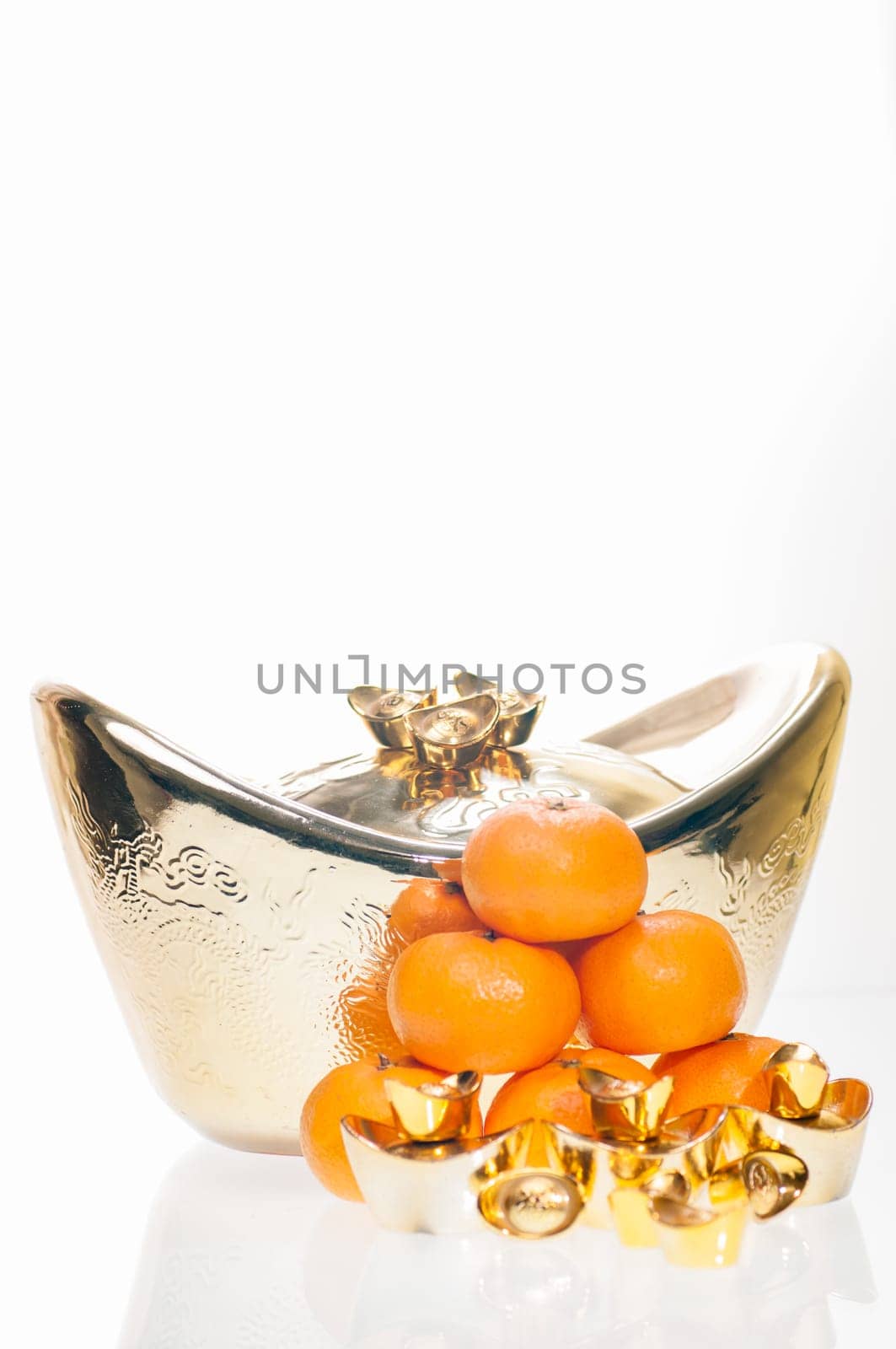 A stack of tangerine with large ingot as background