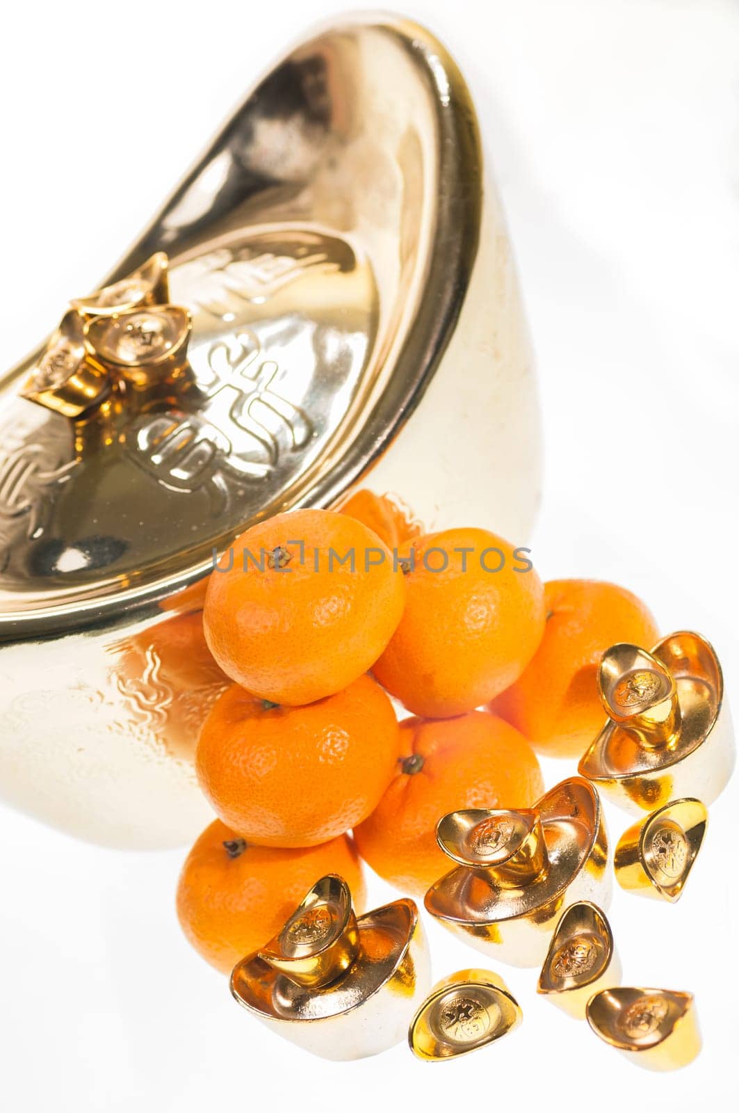 Gold ingots and mandarin oranges over white background