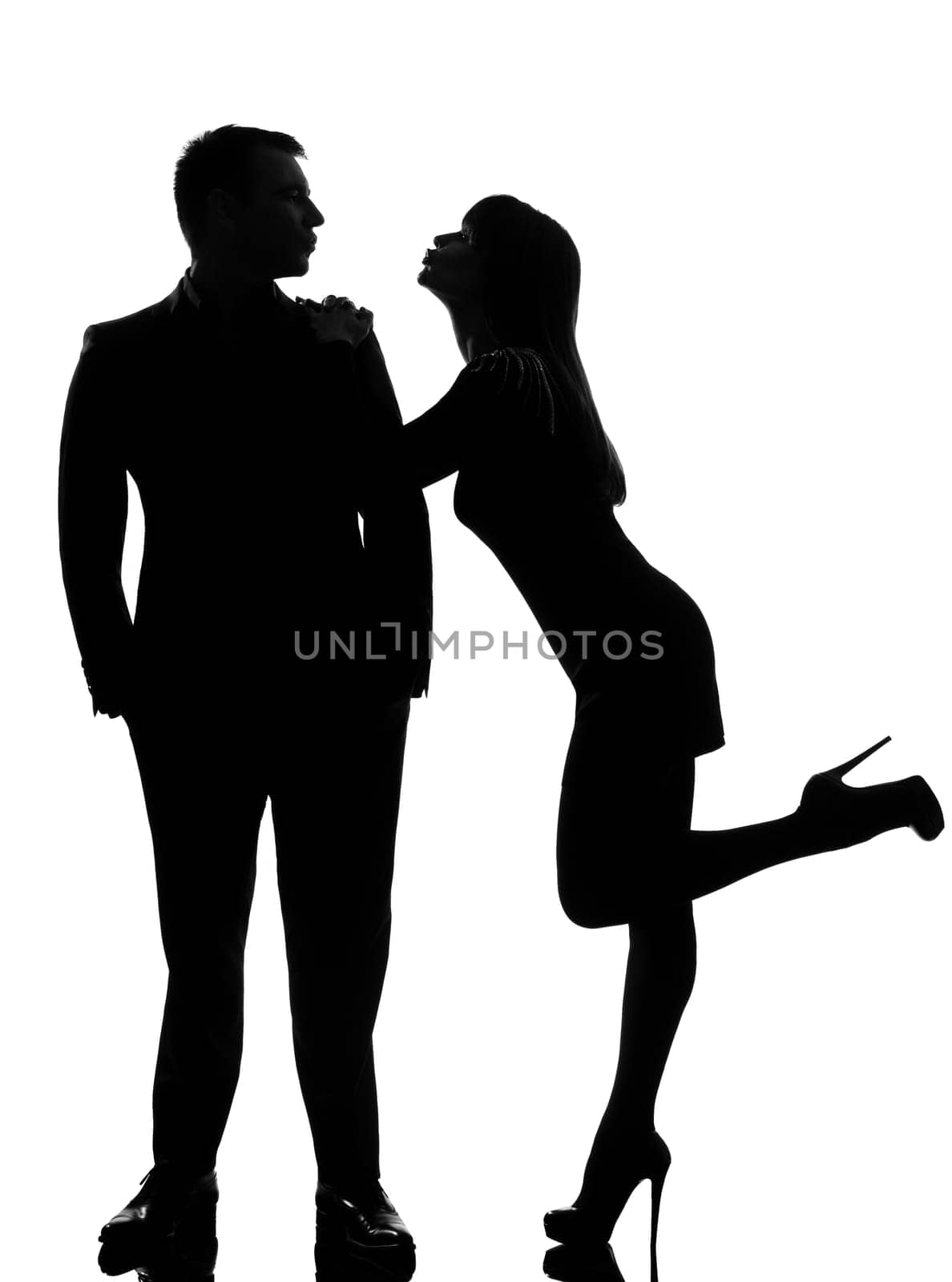 one caucasian couple lovers  woman wanting to kiss the man in studio silhouette isolated on white background