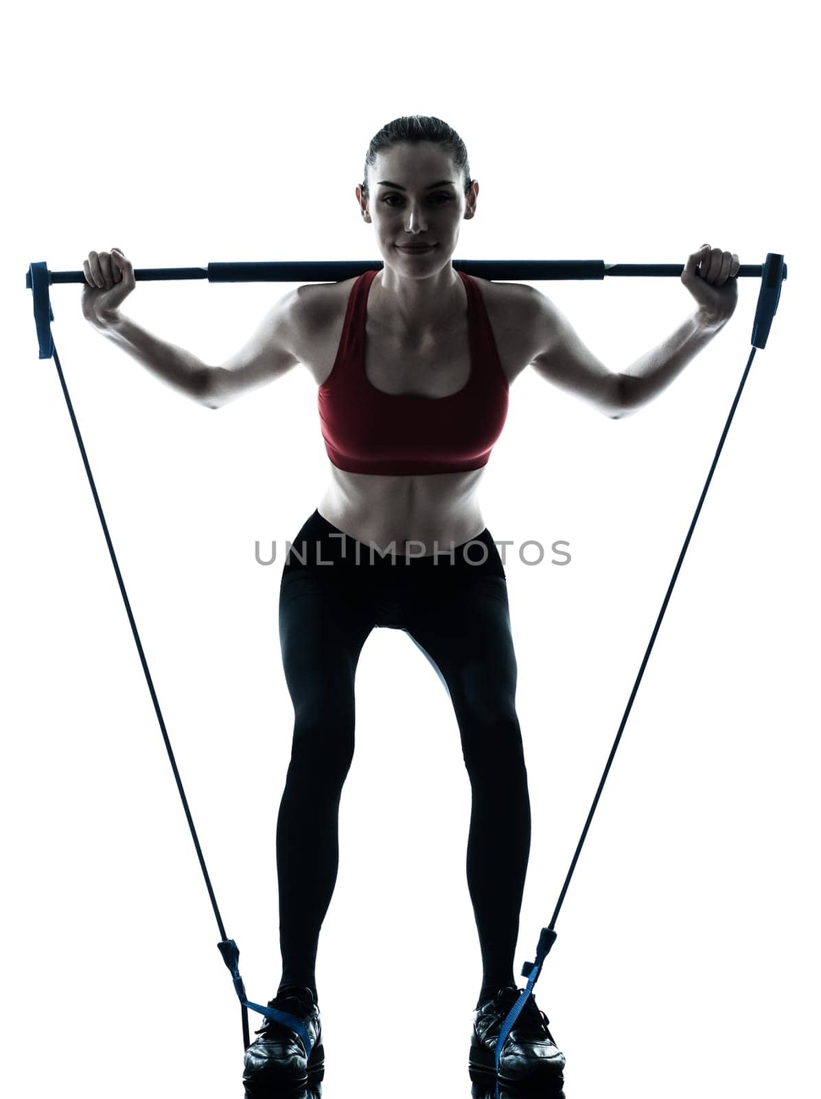one caucasian woman exercising elastic gymstick in silhouette studio isolated on white background