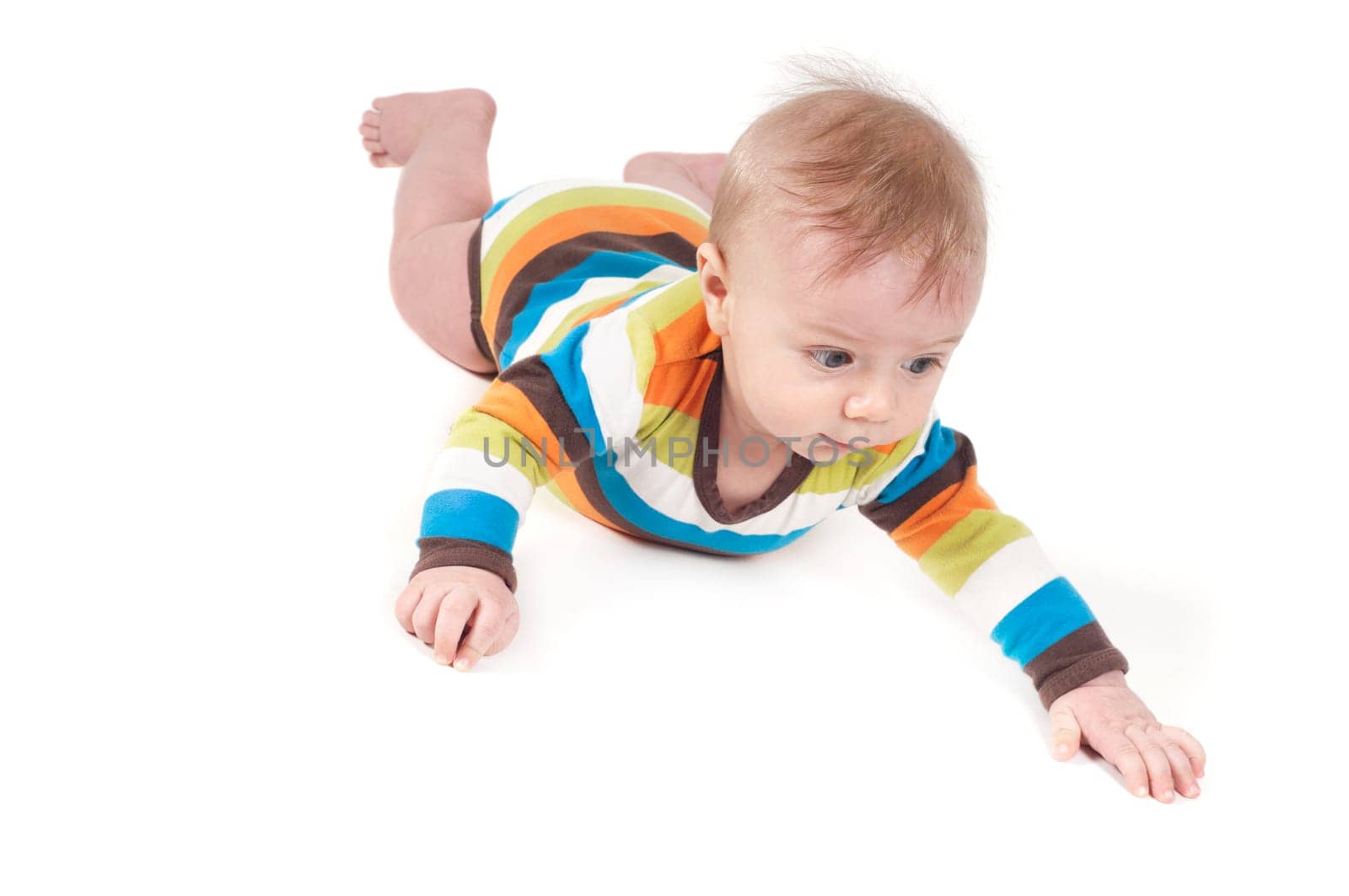 Little baby in multicolored striped clothes lying on white background